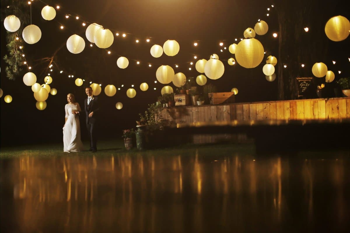 Bride and groom dancing on the bar with guests cheering — wedding lighting and production