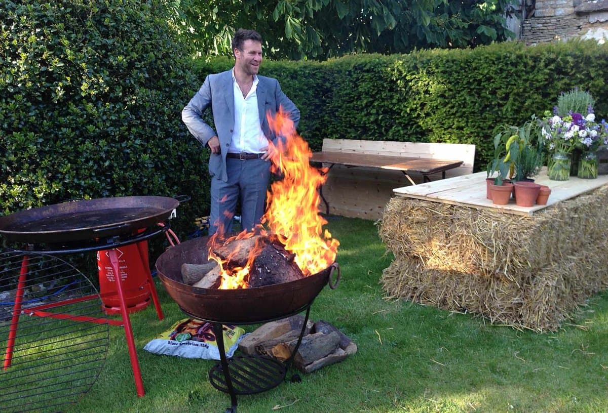 Wedding fire pit hire with hay-bale seating and rustic table styling outdoors