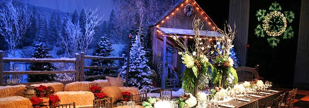 Alpine lodge Christmas party theme with snowy forest backdrop and rustic lounge seating