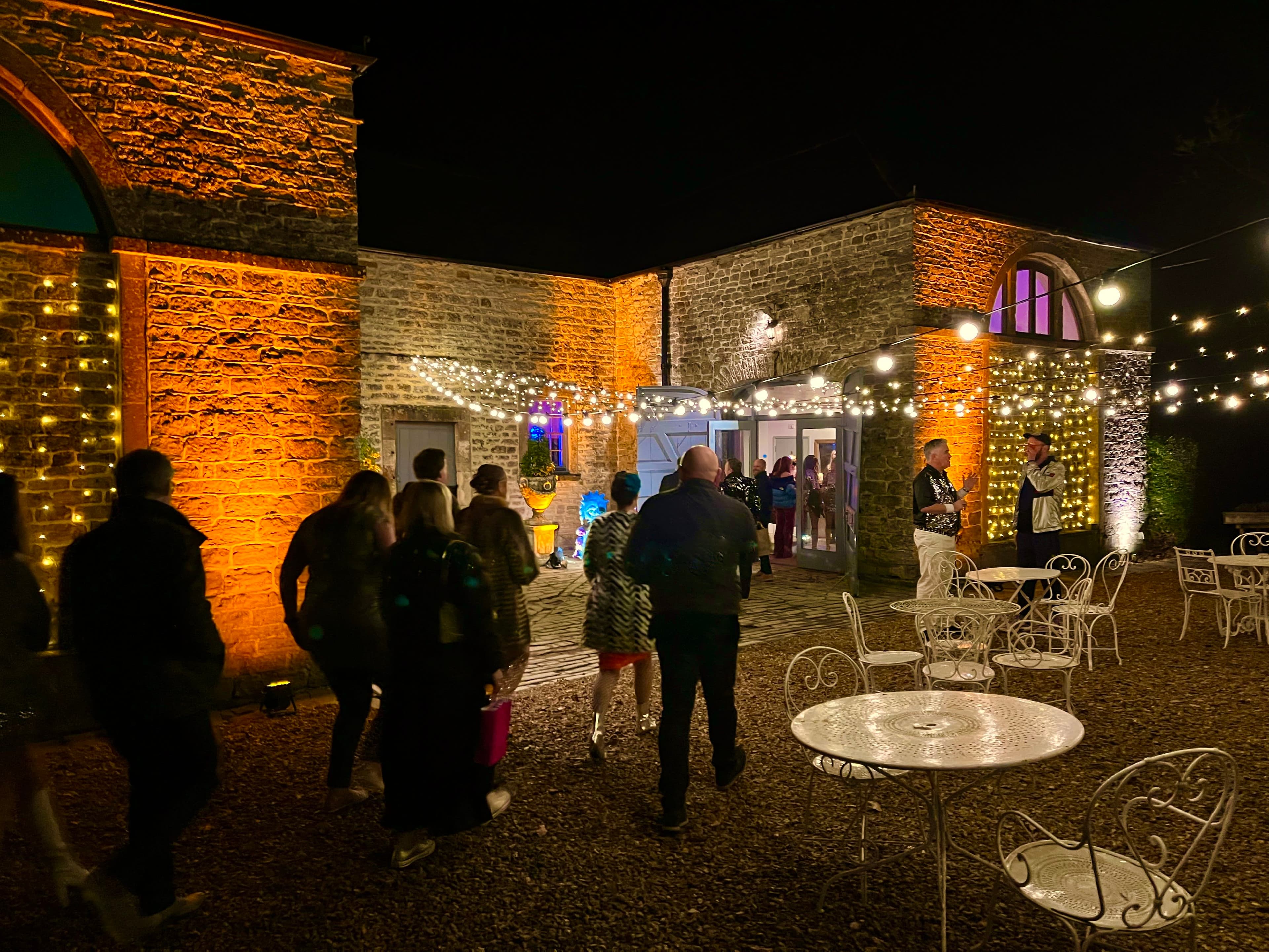 Pennard House with amber uplighting highlighting architectural details for an evening party