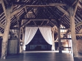 A stunning rustic barn with our fairy-light canopy and white curtains.