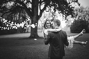 Image of a groom carrying a bride on a lawn