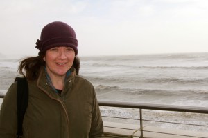 Alison Perice, Director Stylish Entertainment standing in front of waves on a windy day.