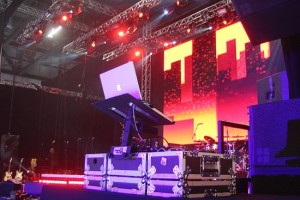 Dj decks and staging at the Excel for a corporate event with video walls behind the decks and an extensive lighting truss above