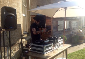 DJ decks outside on a lovely summers day underneath a large cream umbrella