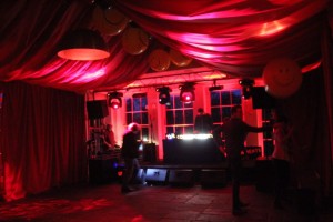 The Orangery at Babington House styled for a festival party with red fabrice tented ceiling canopy. red led lighting