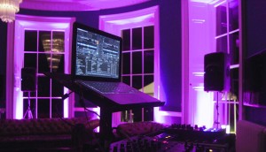 Pink LED up-lighting in the bar at Babington House with Dj decks in the foreground and speakers on stands left and right of the decks.