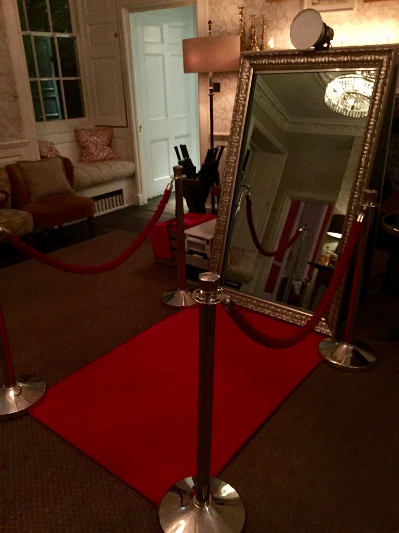 magic mirror photo booth with red carpet ropes and poles in the reception area of a hotel