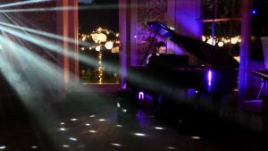 Pianist for weddings at Babington House for a Cocktail Hour with baby grand piano and venue lighting.