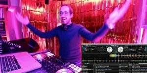 DJ with harsm open and large hands, dj decks shown, gold tassle curtain behind the DJ