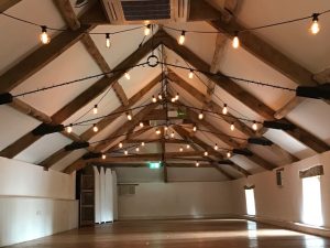 The Coach House at Pennard House with a vintage Edison style bulbs lighting canopy in an empty room