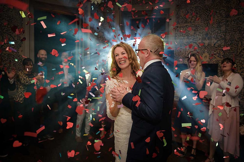 bride and groom dancing with confetti cannon explosion
